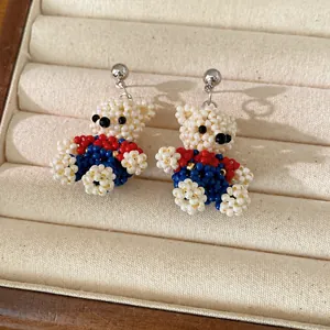 Charming handmade beaded bear earrings featuring white, red and blue pearls for women.