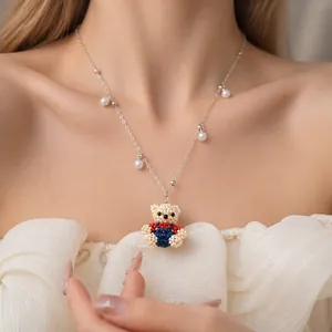 Handmade beaded bear pendant necklace with pearl accents on silver chain