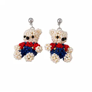 Handmade beaded bear stud earrings with red and blue pearl accents
