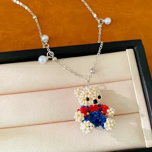 Detailed view of handcrafted beaded bear pendant with pearl accents on a fine chain