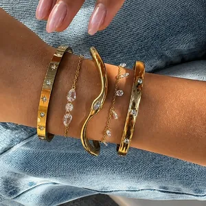 Primo piano di rigidi in acciaio inossidabile dorato e bracciali con zirconi.