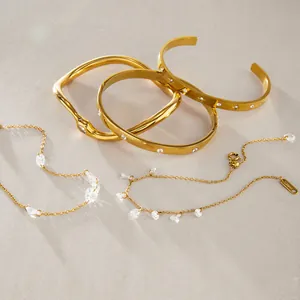 Elegante set di bracciali rigidi in acciaio al titanio dorato e collane con zirconi