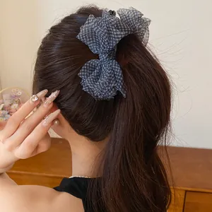 Dettaglio di un fermaglio per capelli coreano con fiocco in chiffon a scacchi elegante