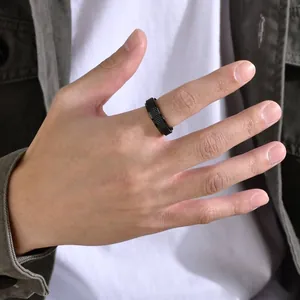 Detailansicht eines schwarzen Edelstahl-Spinner-Rings mit Netzstruktur am Finger getragen