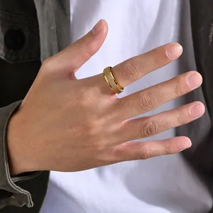 Goldener drehbarer Edelstahlring mit Netzmuster am Finger, stylischer Anti-Stress-Schmuck.