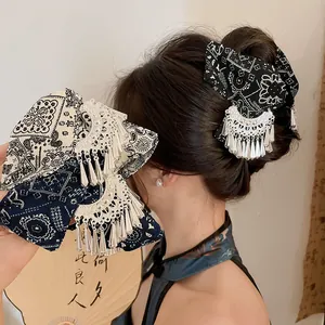 Detailweergave van de etnische haarklem met indigo batikstof en zilveren kwastjes.