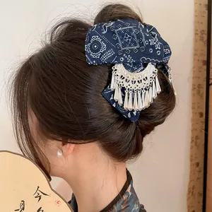 Gedetailleerd aanzicht van blauwe batikstof en zilveren kwastjes op de haarclip