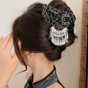 Detailopname van de etnische haarklem met Miao zilveren kwastjes en batik details