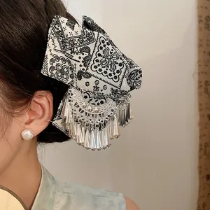 Etnische haarklem met batik stoffen strik en zilveren kwastjes voor chique haarstijlen