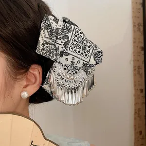 Gedetailleerde opname van een etnische Miao zilveren kwastjes haarklem met een batikpatroon strik