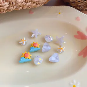 Selection of colorful resin DIY charms with starfish and sun shapes on a decorative plate.