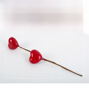 Macro detail of red heart-shaped artificial berry branch for DIY flower arrangement