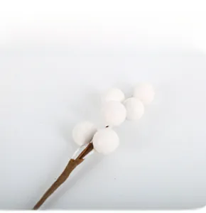 Close-up of white decorative berries on a brown stem for holiday DIY floral arrangements