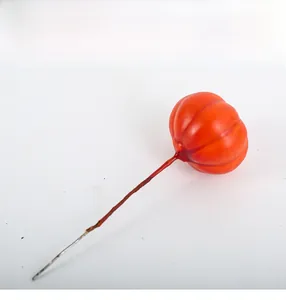 Close-up of an orange artificial berry decoration on a brown wire stem