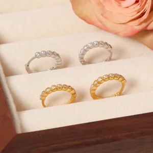 Detailansicht von vergoldeten und versilberten Creolen mit glitzernden Zirkonias in Box