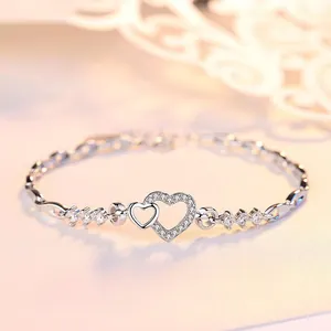 Elegant S925 silver interlocking heart bracelet with shimmering cubic zirconia accents