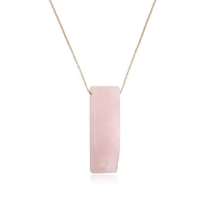 Detailed close-up of a rectangular rose quartz stone pendant on a thin gold chain necklace.