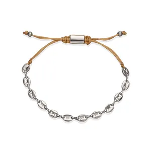 Detailed macro view of a stainless steel coffee bean link bracelet with tan cord.