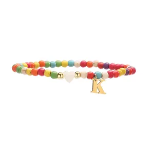 Bracelet de cheville en turquoise colorée avec breloque lettre K dorée en cœur.