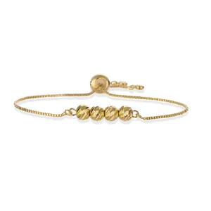 Detailed macro view of four faceted gold beads on a delicate adjustable box chain bracelet