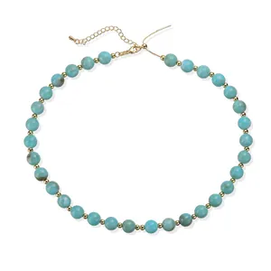 Gros plan exquis d'un collier de perles en acrylique marbré bleu clair avec entretoises dorées