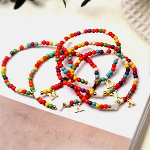 Gros plan détaillé de bracelets de cheville bohèmes avec lettres et cœurs dorés.