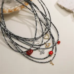 Detailed macro view of multi-strand necklace featuring heart, butterfly, and key charms