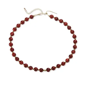 Vue détaillée d'un collier en perles acryliques rouges avec perles d'espacement dorées