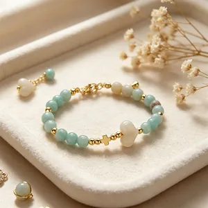 Dettaglio di un bracciale in pietra naturale con perline dorate e ciondolo a cuore
