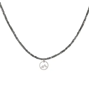 Detailed view of beaded necklace with mountain silhouette pendant in silver finish