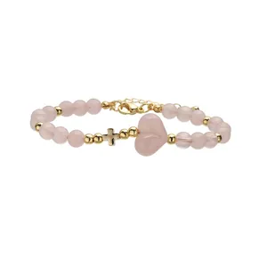 Vista dettagliata del bracciale in quarzo rosa con ciondoli a cuore e croce dorati chic