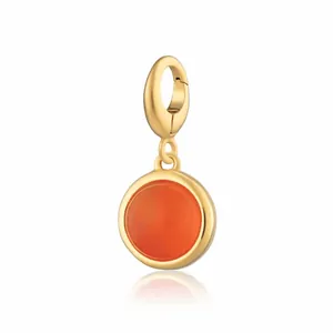 Primo piano di un ciondolo rotondo in agata corniola arancione placcato in oro 18K.