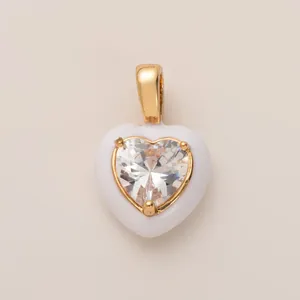 Toma detallada de un colgante de corazón blanco con una piedra de circonita tallada brillante.