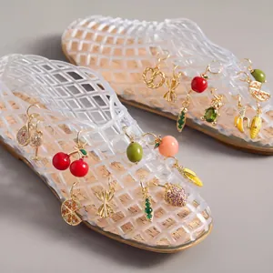 Detail showing colorful fruit and food charms attached to transparent jelly shoes