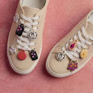 Colorful decorative shoe charms with floral and star patterns on beige sneakers