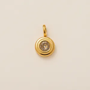 Detailed view of a circular gold-plated stainless steel shoe charm with clear zircon stone