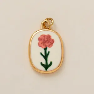 Detailed macro view of the pink floral pattern on a gold-plated oval pendant accessory
