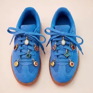 Detailed macro view of colorful DIY 12 birthstone shoe charms on blue suede sneakers