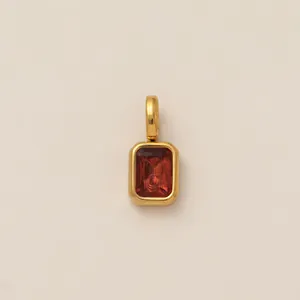 Close-up of a rectangular red zircon pendant in 18K gold vacuum-plated stainless steel.