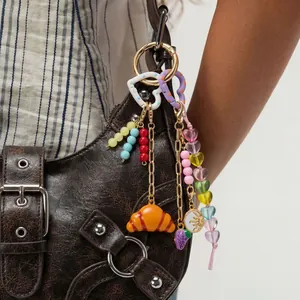 Detailed view of DIY colorful bag charms featuring croissant and heart-shaped motifs