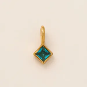 Detailed view of a square blue zircon birthstone charm with 18K gold plated stainless steel frame