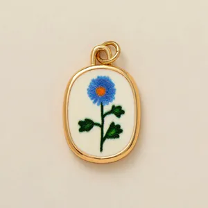 Macro view of a gold-toned oval pendant featuring a delicate blue flower print