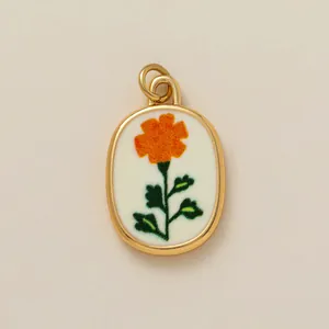 Close-up of gold oval pendant featuring an orange flower with fuzzy texture