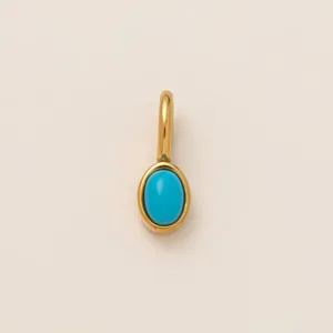 Detailed macro view of a gold-plated stainless steel oval turquoise charm for DIY jewelry