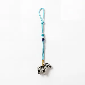 Handmade zebra animal charm keychain with blue braided cord and decorative beads detail