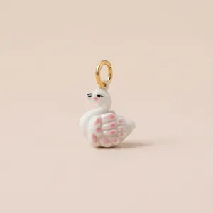 Detailed close-up view of a handcrafted white ceramic swan charm with 18K gold plated ring