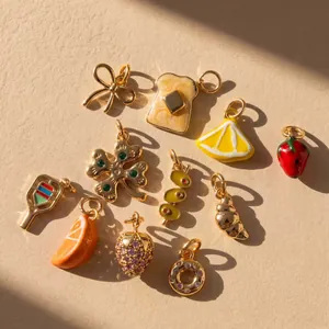 Close-up of various golden DIY charms including lemon, strawberry, and toast shapes