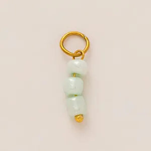 Dettaglio di perle di giada verde menta su un ciondolo in acciaio inossidabile placcato oro 18K