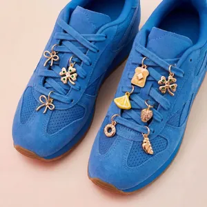 Detailed close-up of creative gold DIY shoe charms featuring lemon toast and clover shapes