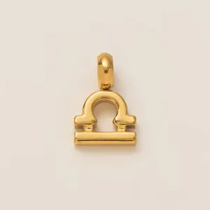 Close-up detail of a minimalist 18K gold-plated stainless steel Libra zodiac pendant charm
